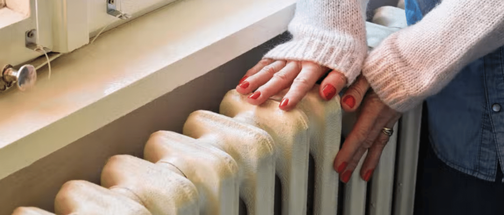 Image of a woman's hand touching a radiator